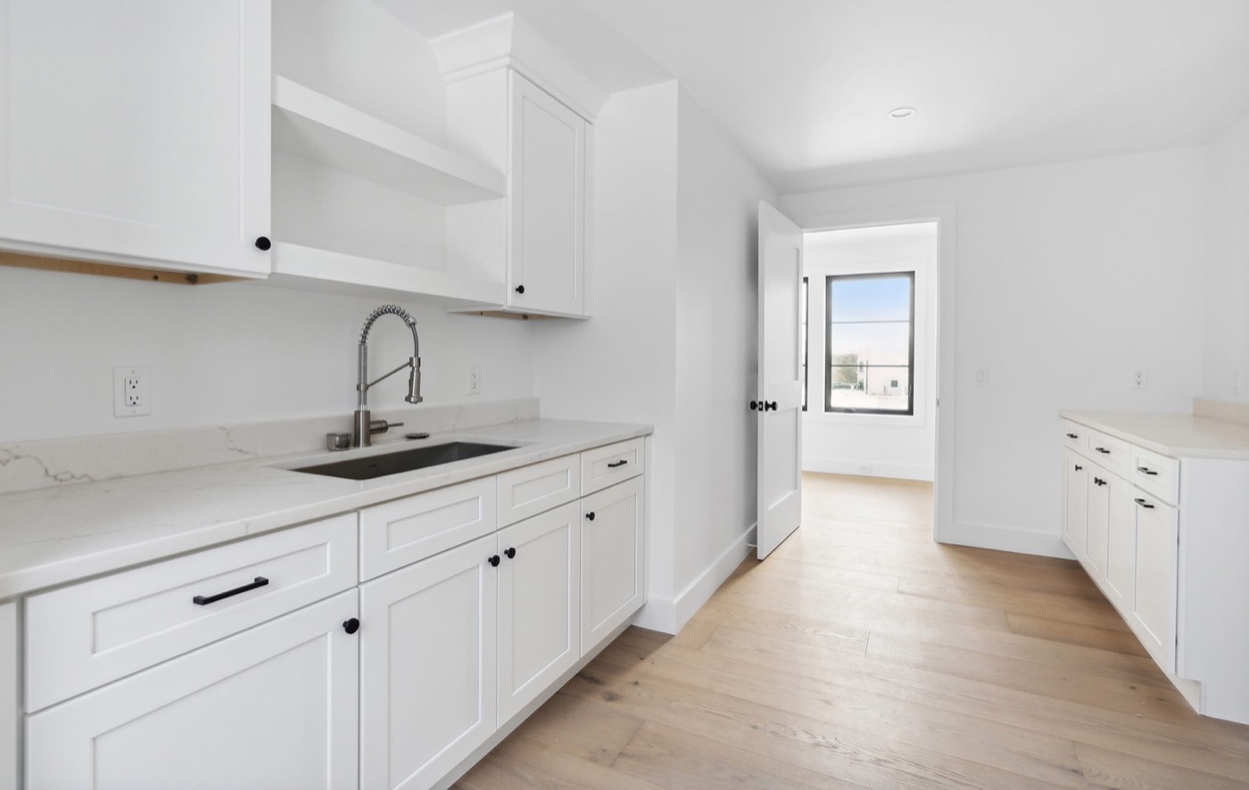 Dura Supreme Cabinetry All-white modern farmhouse laundry room, available at Shoreline Cabinet Company in Wilmington, NC
