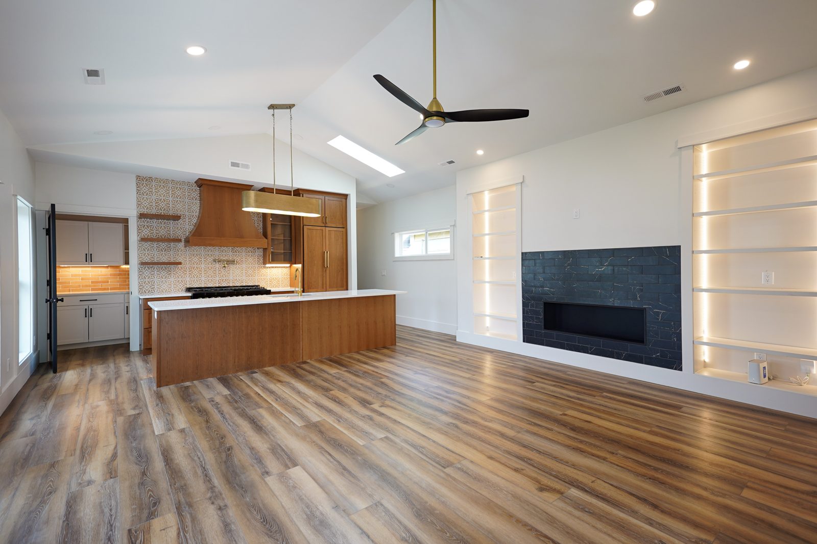 Open-plan cherry kitchen seen from the living room by Shoreline Cabinet Company, Wilmington NC