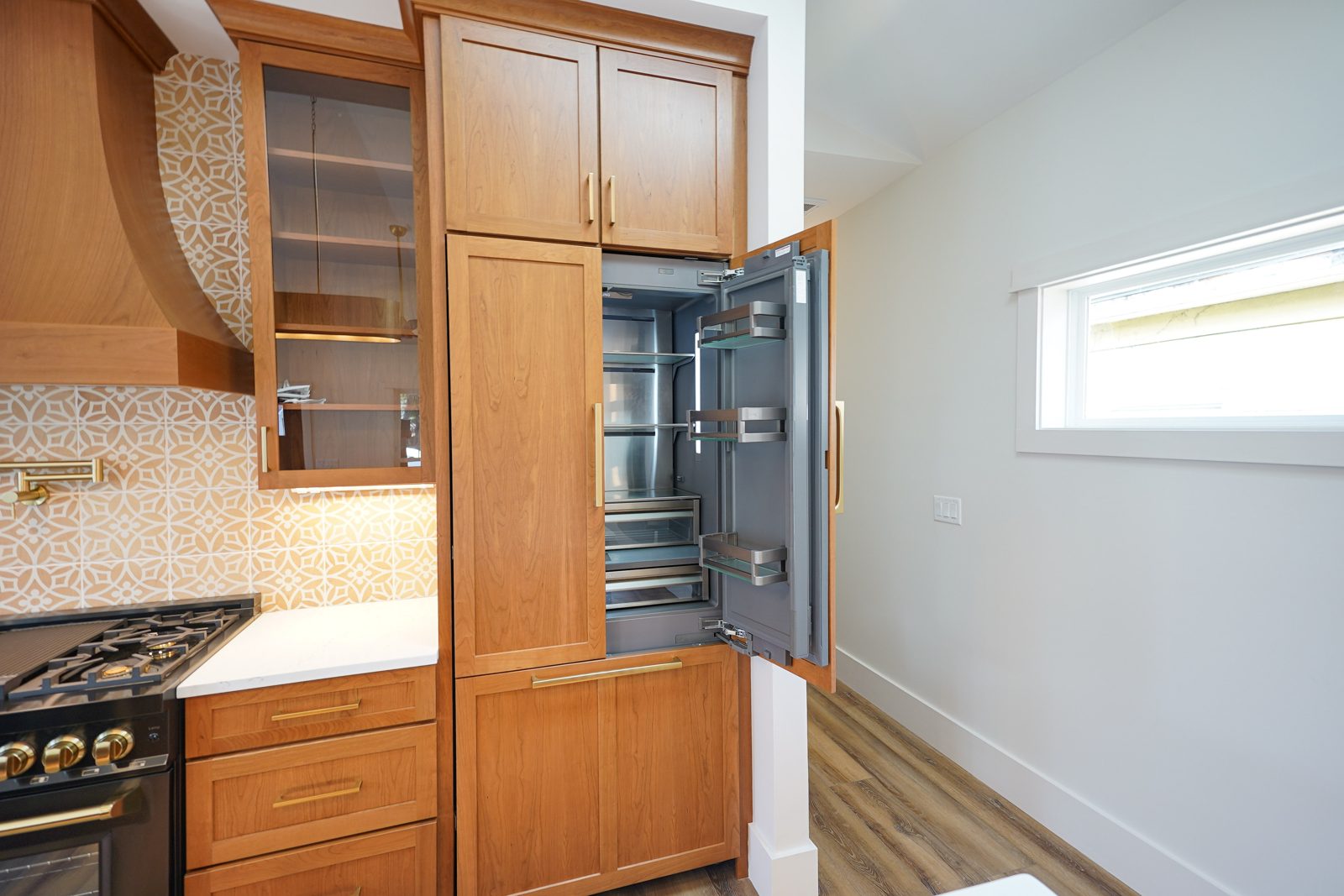 Panel-ready refrigerator behind cherry cabinet doors by Shoreline Cabinet Company, Wilmington NC