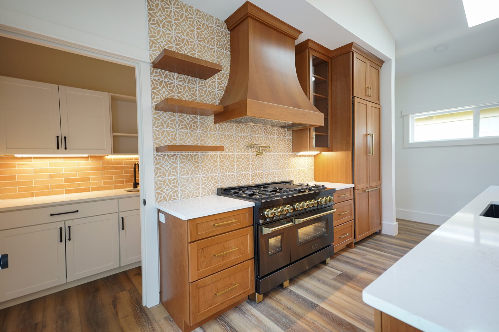 Cherry range wall with lit floating shelves by Shoreline Cabinet Company, Wilmington NC