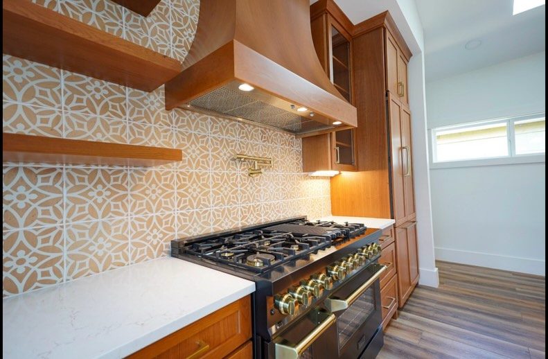 Cherry cabinetry range wall with a custom wood hood