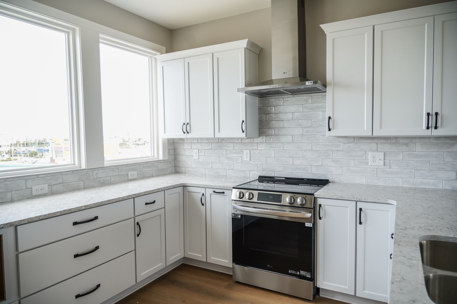 Shaker kitchen cabinets and range between two windows by Shoreline Cabinet Company, Wilmington NC