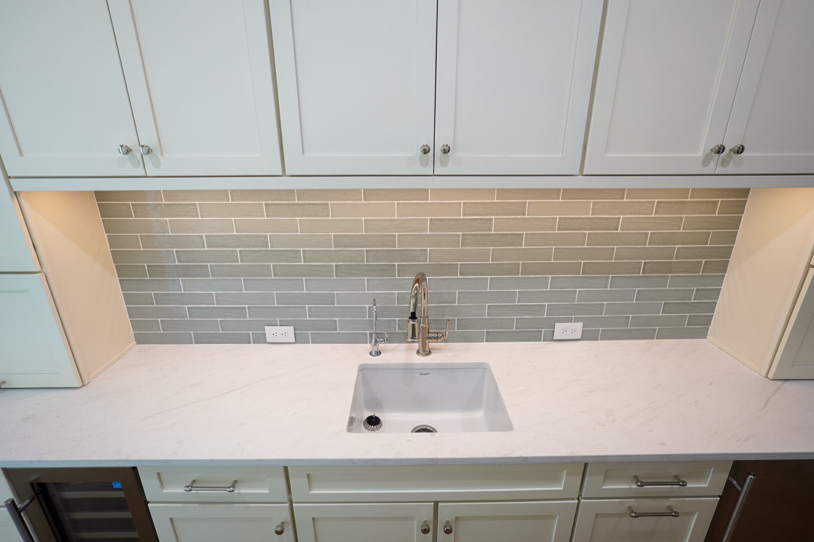 Grey-green subway tile in a white galley kitchen by Shoreline Cabinet Company, Wilmington NC
