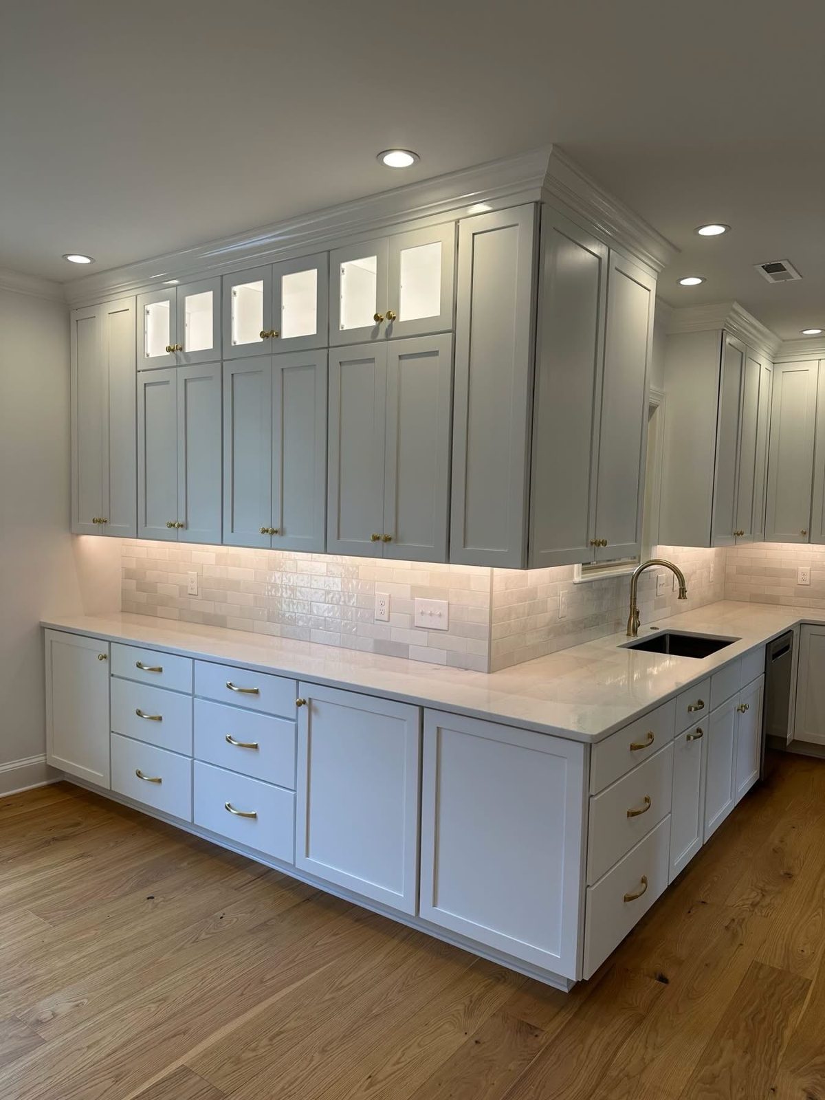 Lit glass-front upper cabinets by Shoreline Cabinet Company, Wilmington NC