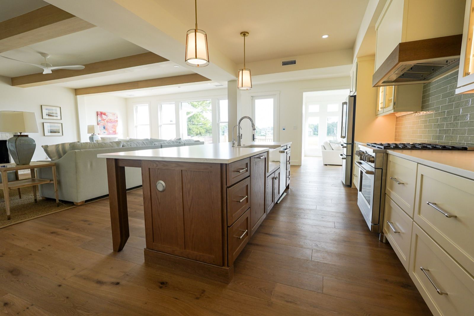 Open-plan kitchen with a stained oak island and cream cabinetry by Shoreline Cabinet Company, Wilmington NC