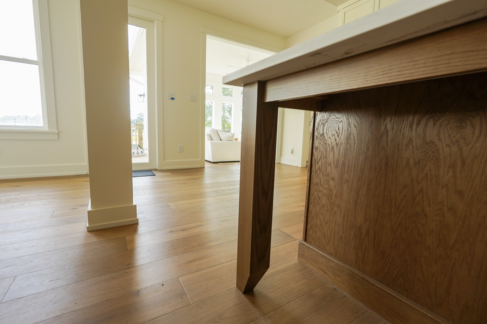 Stained oak island with a furniture-style corner leg by Shoreline Cabinet Company, Wilmington NC
