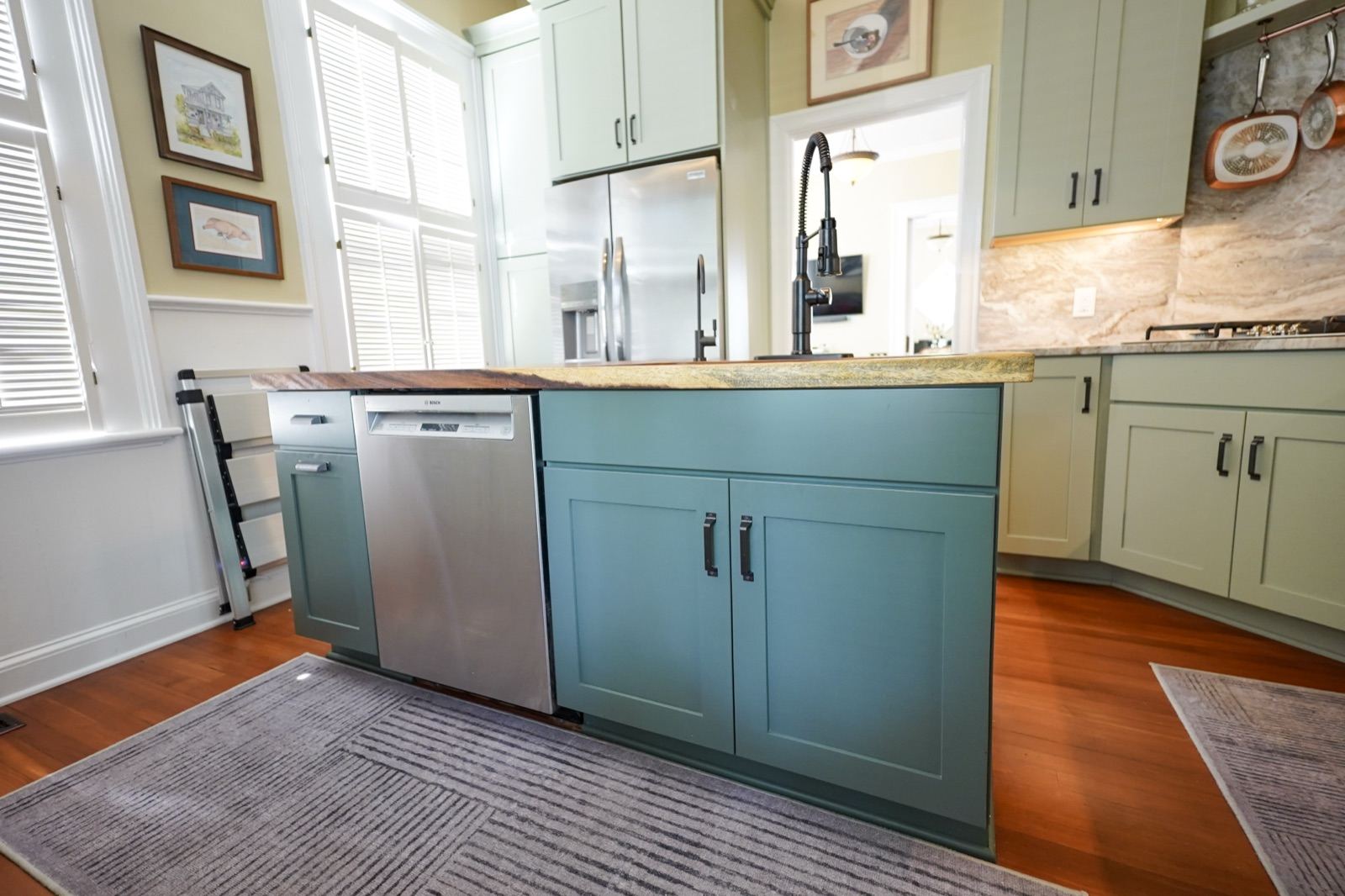Teal kitchen island with sage green cabinets by Shoreline Cabinet Company, Wilmington NC