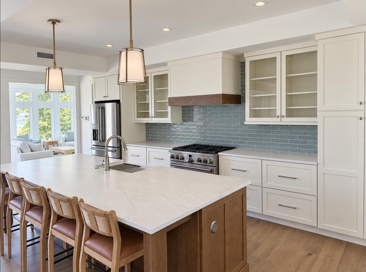 White kitchen with blue glass subway tile and an island by Shoreline Cabinet Company, Wilmington NC