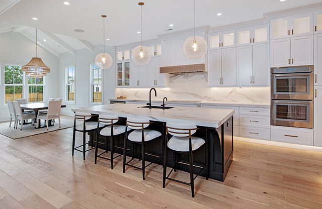 White kitchen with a dark island and woven pendants by Shoreline Cabinet Company, Wilmington NC