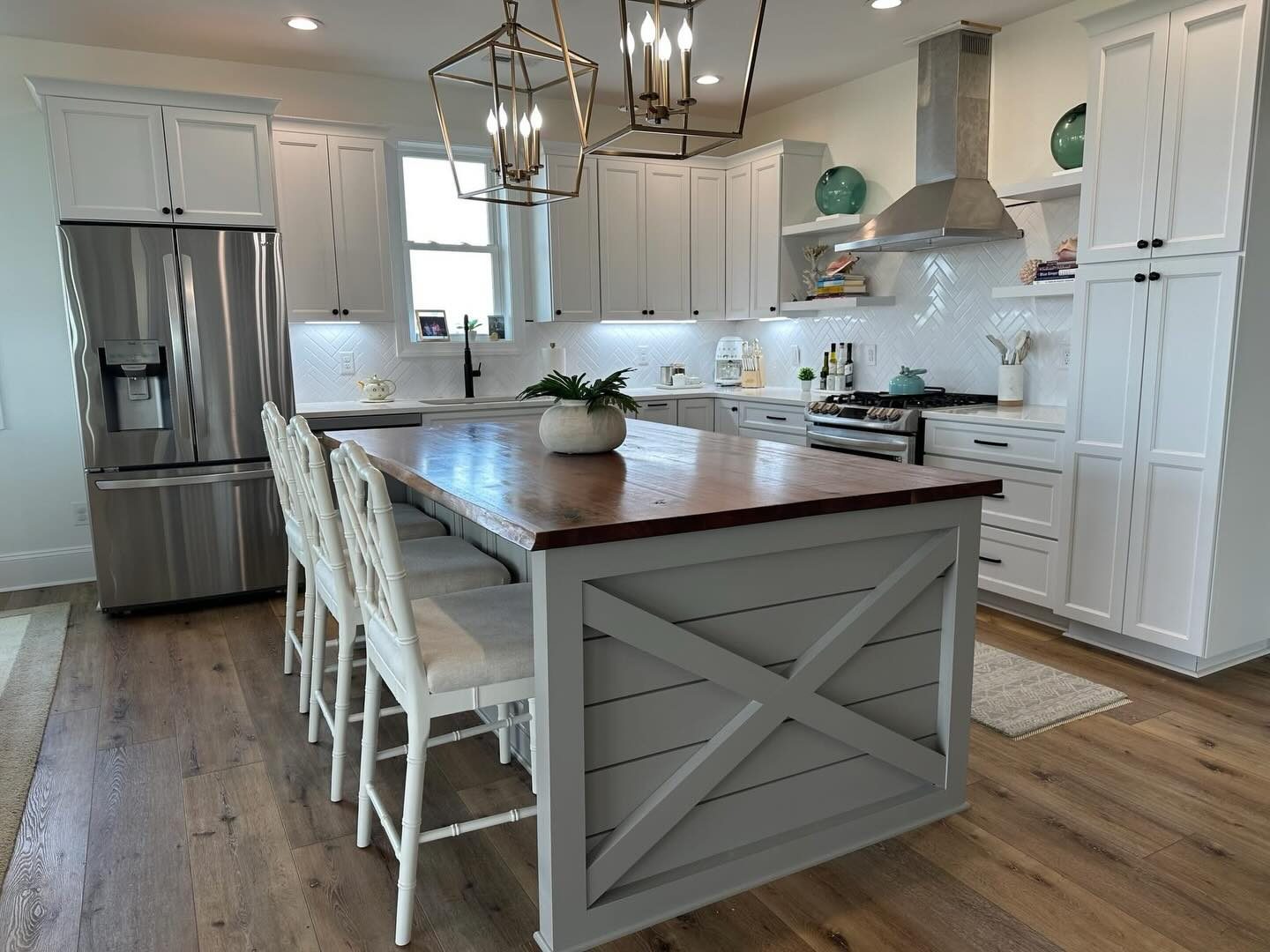 White shaker kitchen with an X-brace island and lantern pendants by Shoreline Cabinet Company, Wilmington NC