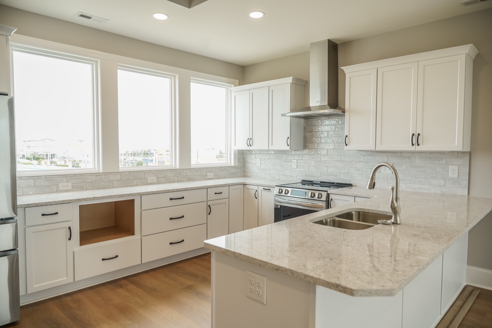 White shaker kitchen with quartz island by Shoreline Cabinet Company, Wilmington NC